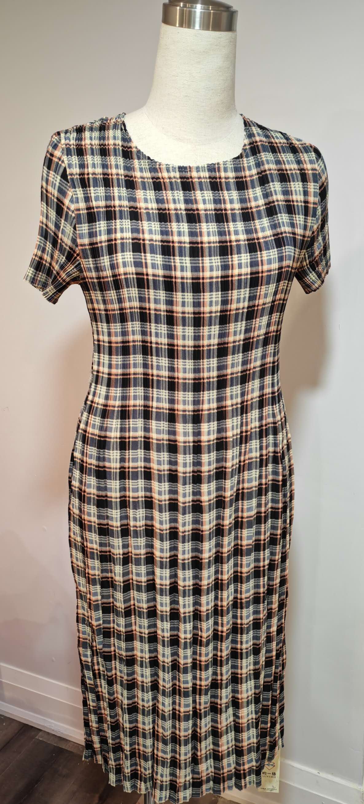 Plaid dress on a mannequin against a white wall