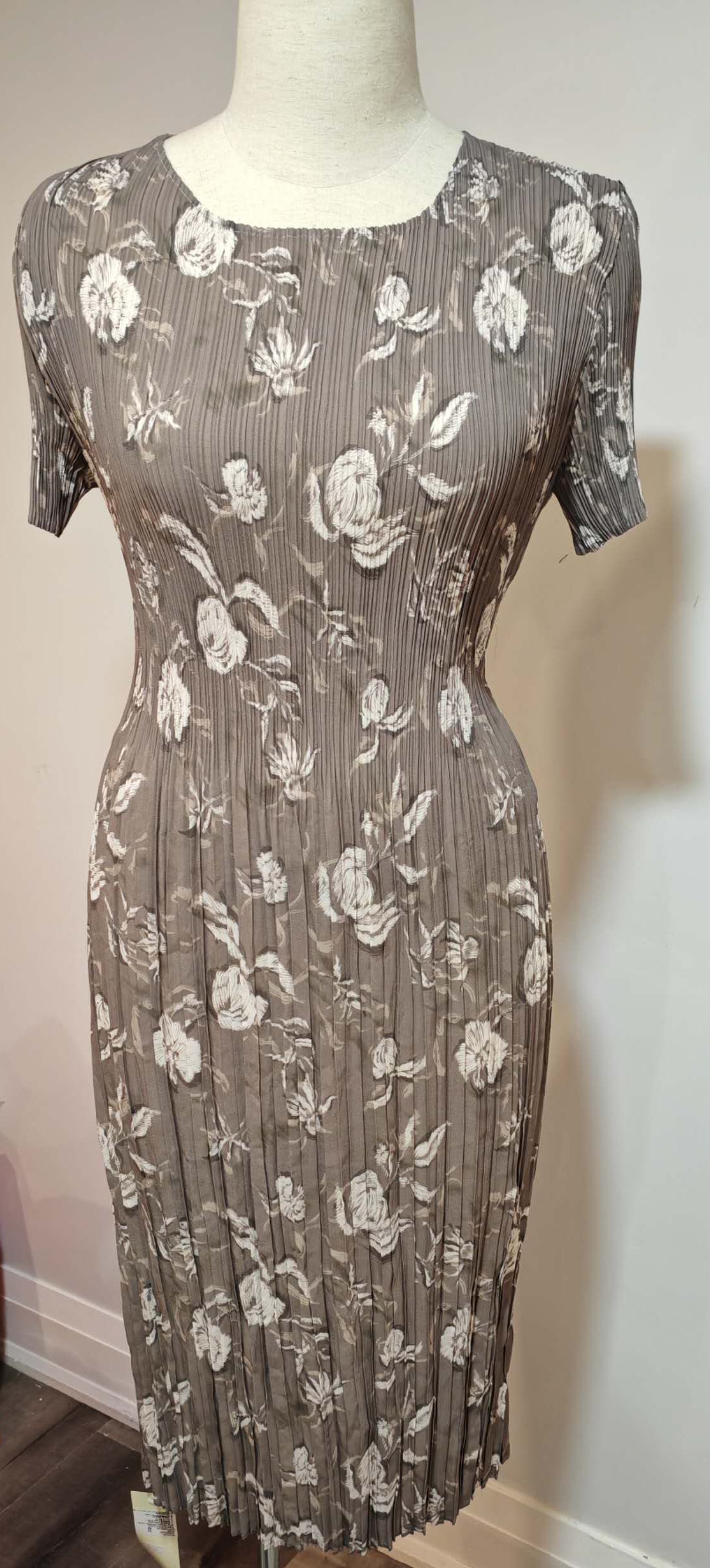 Floral dress on a mannequin against a plain wall