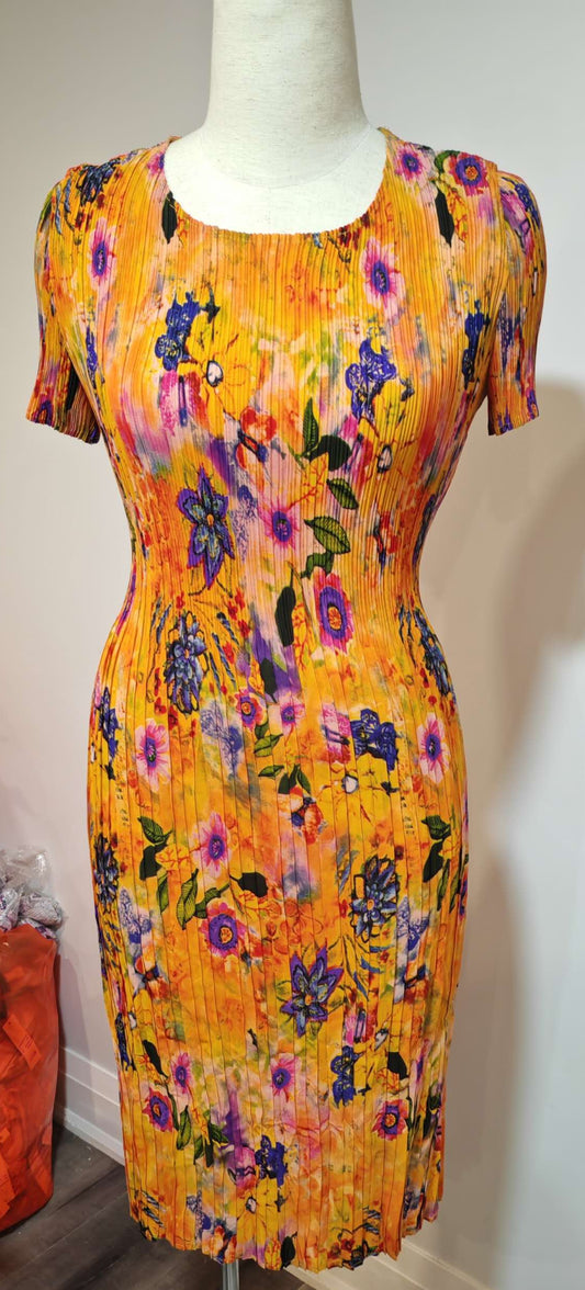 Colorful floral dress on a mannequin against a plain wall.