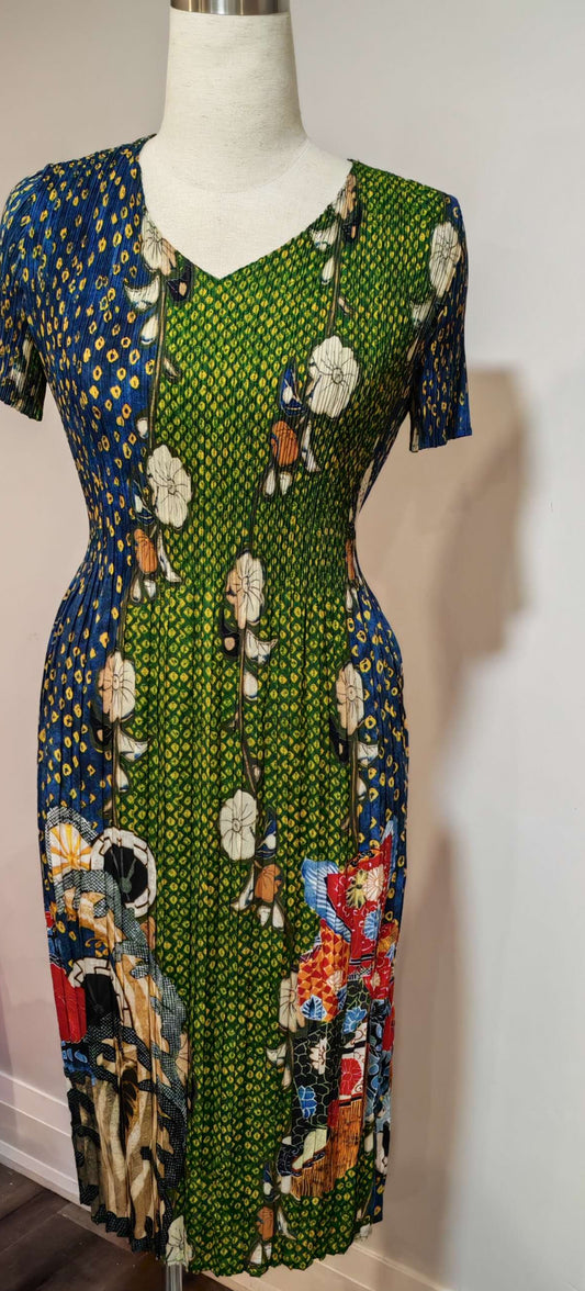 Mannequin wearing a colorful patterned dress against a white wall.