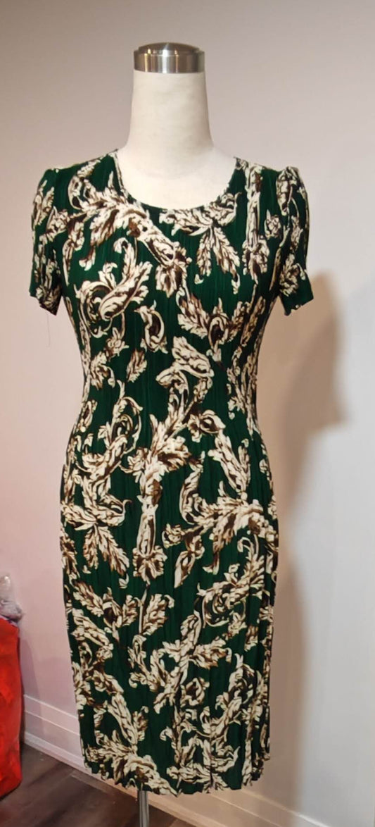 Green and white patterned dress on a mannequin against a plain wall.