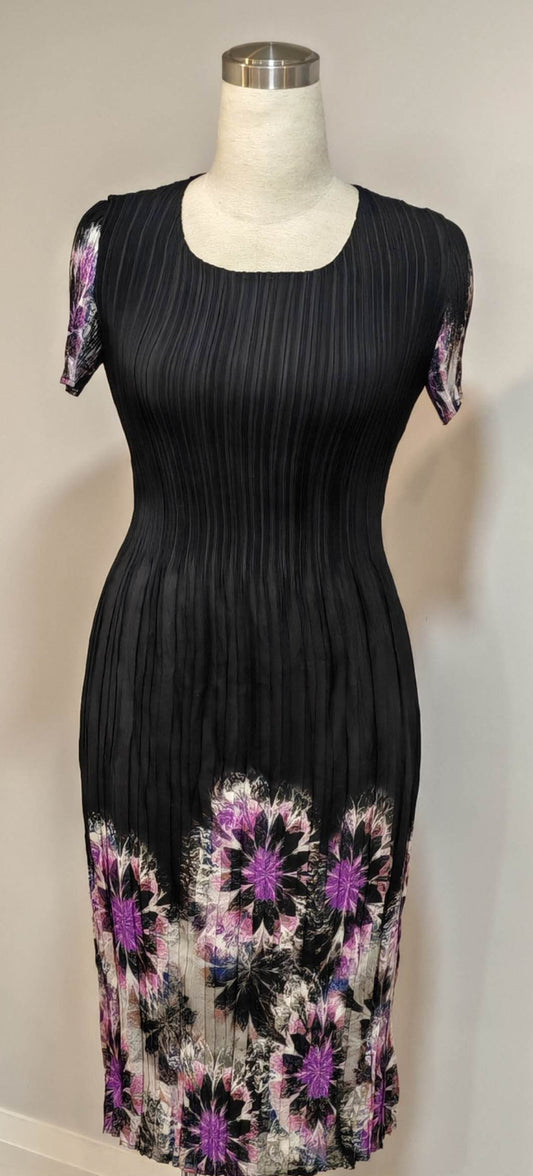 Black dress with floral patterns on a mannequin against a plain background