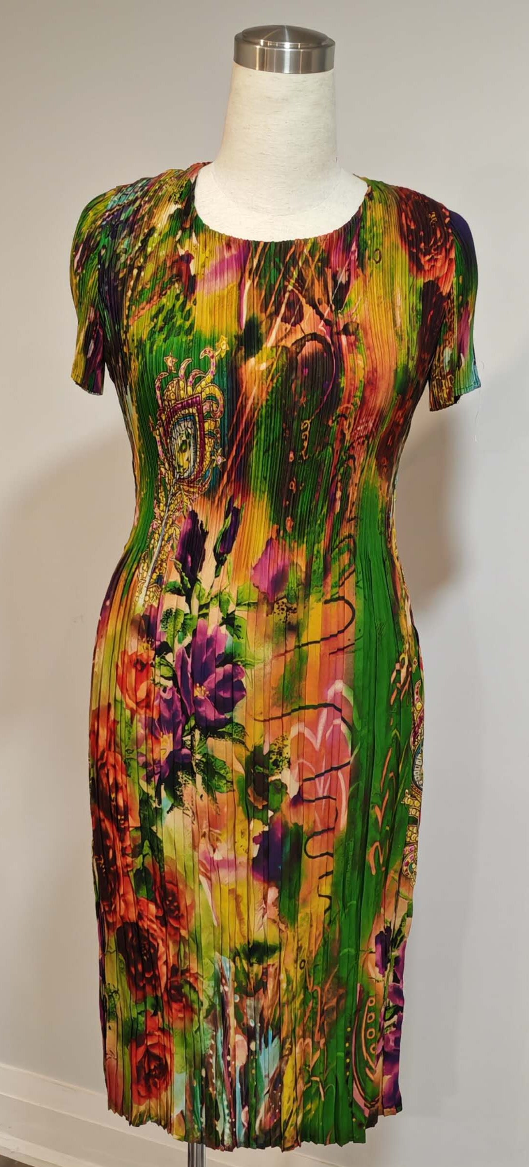 Colorful floral dress on a mannequin against a plain background