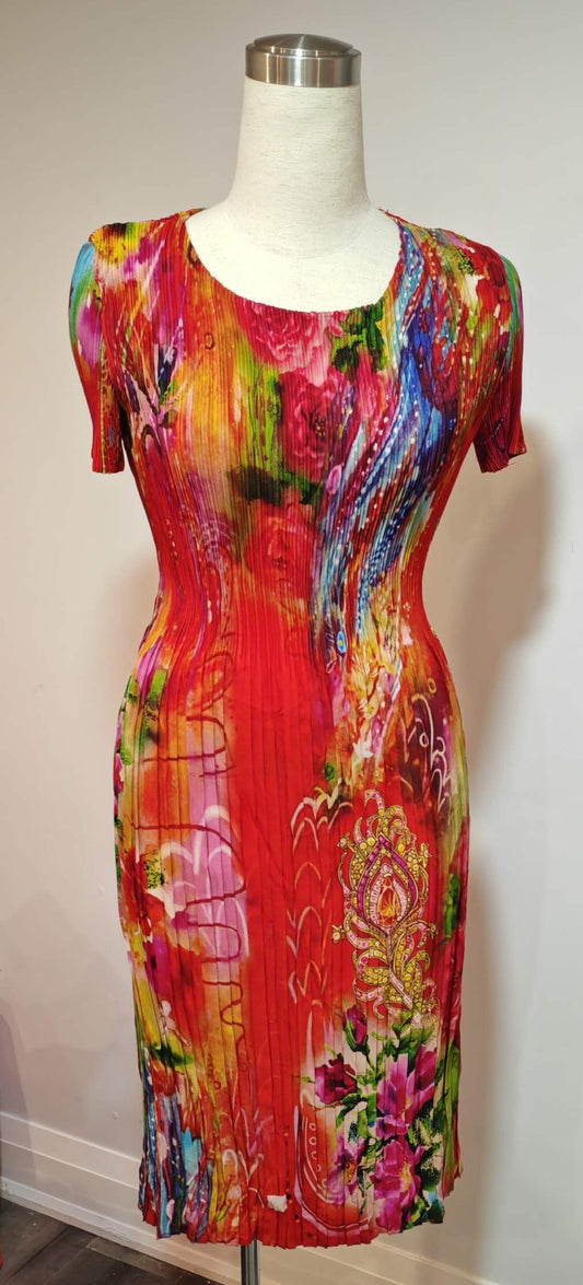 Colorful dress on a mannequin against a plain wall.