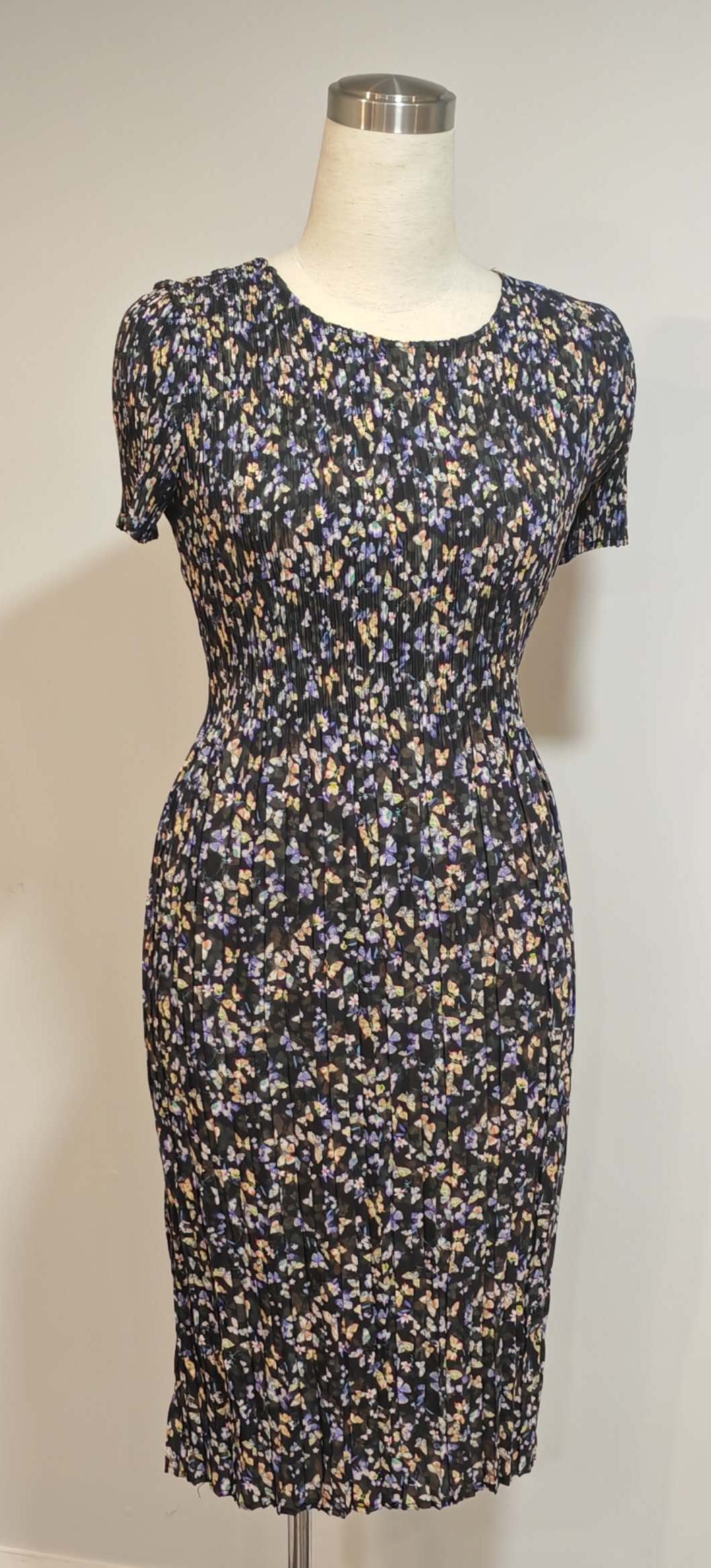 Floral dress on a mannequin against a white wall with a visible camera model 'HONOR 100 Pro'.